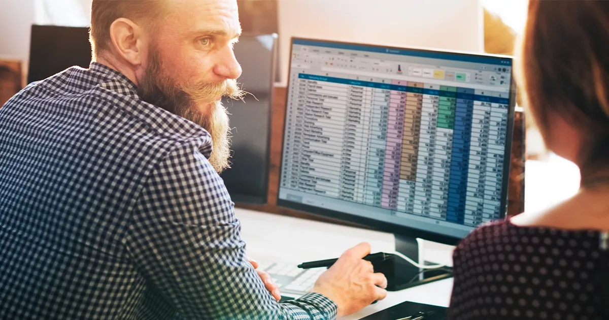 Equipo de ventas revisando datos de clientes en pantalla, ambiente de oficina LATAM